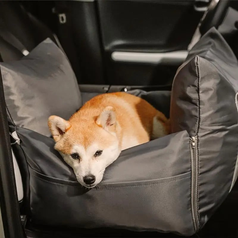 Dog resting in a charcoal grey DockSeat dog car seat on a car's back seat