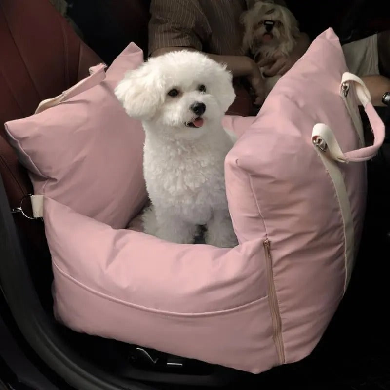 Small white dog sitting in a blush pink DockSeat dog car seat