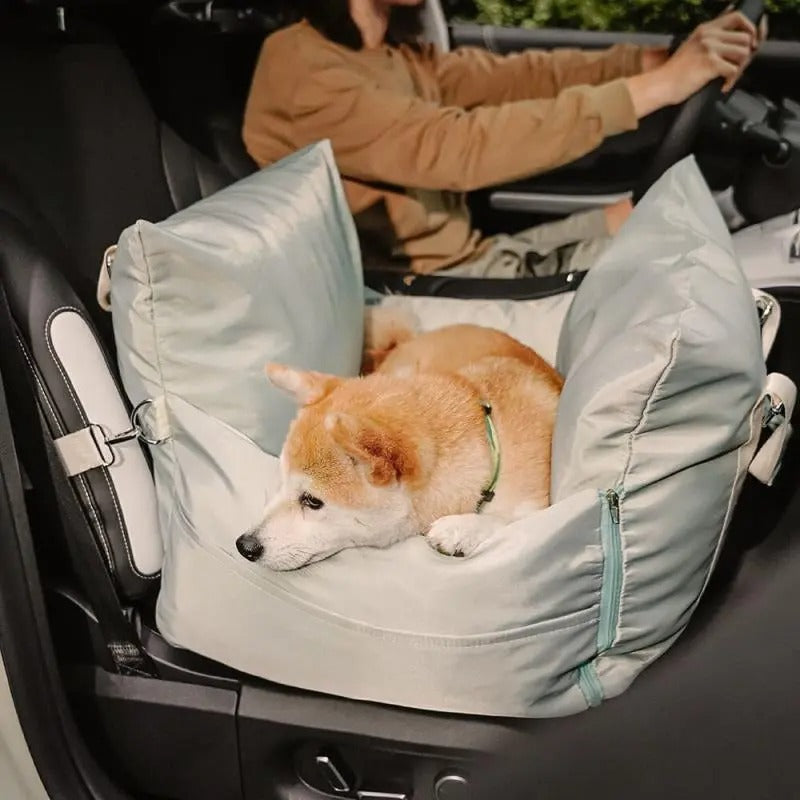 Dog lying in a sage mint DockSeat dog car seat while the owner drives
